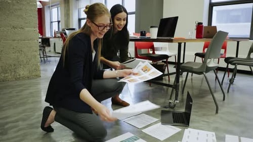 Creative Businesswomen Reviewing Proofs on Office Floor 2024 Years