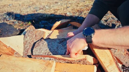 A Person is Burning Freshly Cut Firewood to Turn it Into Charcoal - Close Up