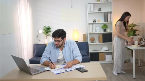 Couple Work Together Using Laptop at Home