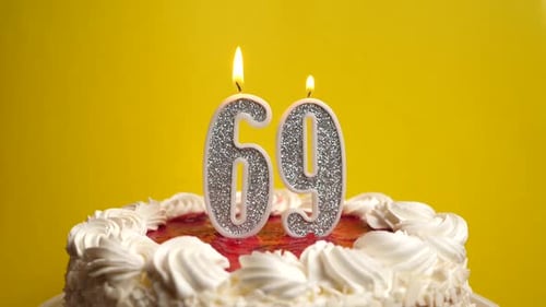 69. A candle in the form of the number 69, inserted into the holiday cake, is blown out. Celebrating