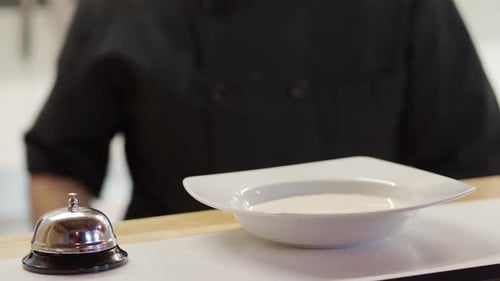 Detail of an Unrecognizable Chef Serving a Plate of Cream in a Restaurant