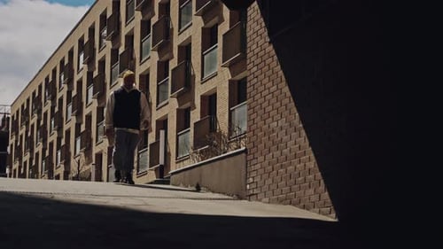 Young Adult Walking Near Brick Building in City