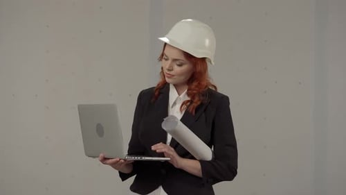 A Woman Architect Works on a Laptop Studies Plans Prints Reports Business Woman in a Protective