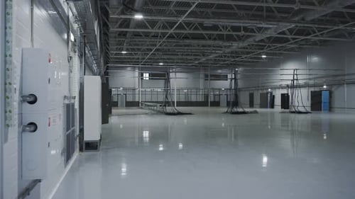 Cables Hang on Metal Beam in Brightly Lit Warehouse
