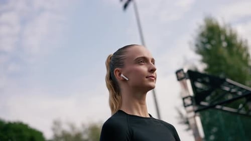 Young Woman Warming Up Outside with Earbuds