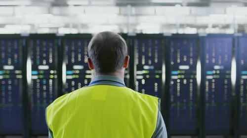 Technician Inspecting Data Servers in Modern Server Room