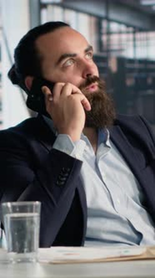 Bearded Man Talking on Phone in Modern Office