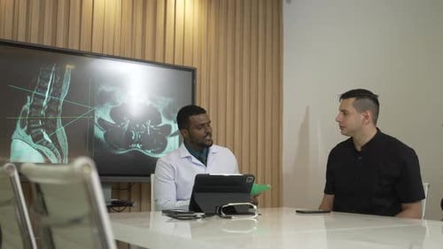 Doctor Reviews X-Ray With Couple in Modern Office