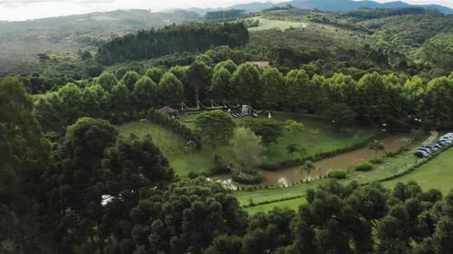 Reveal trough trees shows gorgeous outdoor wedding ceremony set up
aerial view chairs and arch for a