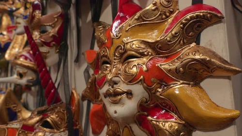 Detailed close-up of ornate Venetian carnival masks in vibrant colors and intricate designs on displ