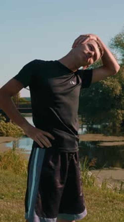 Athlete doing stretching exercises on yoga mat in summer park. Vertical video
