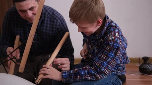 Father and Son Assemble Furniture From Small Parts Little Boy Helps His Father to Assemble a Chair