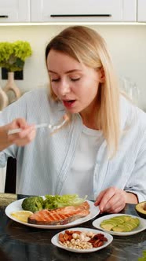 Woman Eating Healthy Meal of Salmon and Vegetables