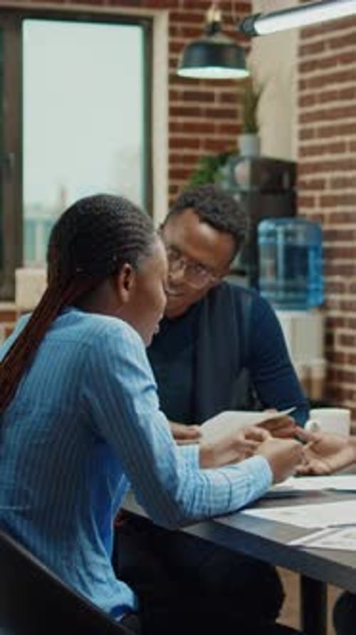 Office Workers Reviewing Documents at Desk