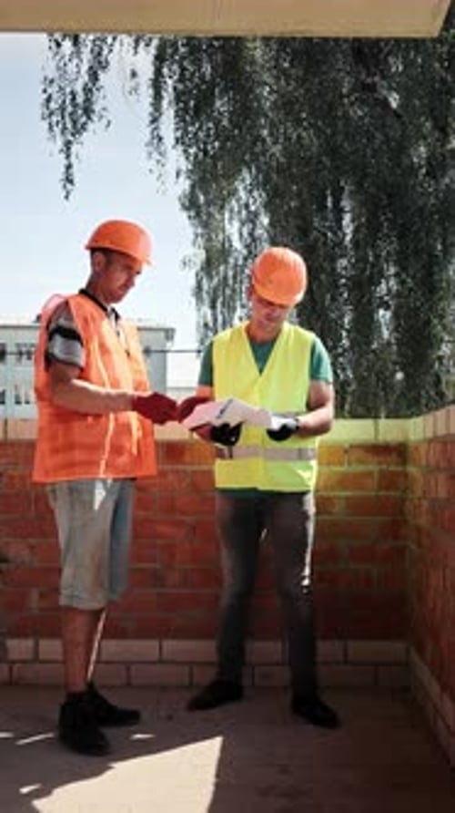 Men Reviewing Blueprints on Construction Site