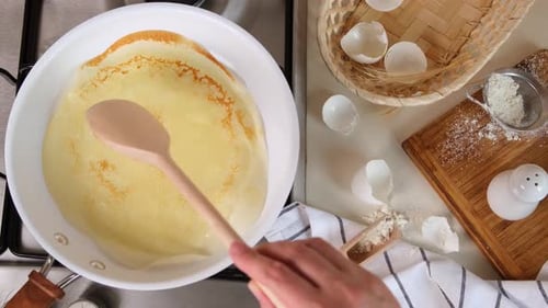 Female Hands Prepare Pancakes or Crepe Roll in a Frying Pan Woman Turn Over a Wooden Pancake with a