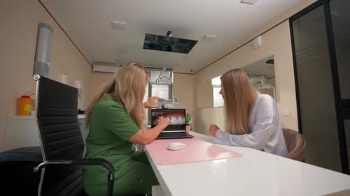 Dentist Explains Dental Treatment to Patient in Office