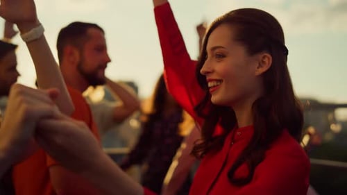 Cheerful Friends Dancing on Rooftop at Sunset