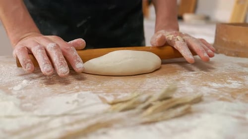 Person Rolls Dough in a Kitchen Close Up