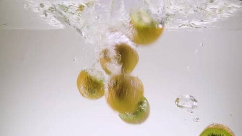 Kiwi Fruit Slices Falling in Water
