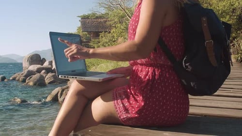 Mulher adulta trabalhando em computador portátil, tecnologia de tela de toque no Pier Of