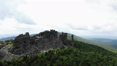 Rugged Mountain Ridge with Rocky Cliffs Overlooking a Vast Forest