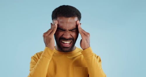 Adult Man Experiencing Pain Against Light Blue Background