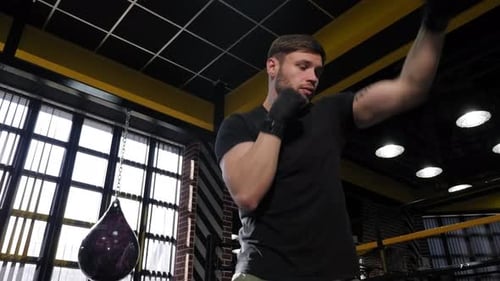 Young Muscular Man Practicing Punches in the Boxing Ring