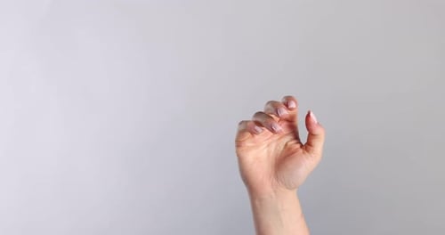 Woman showing her palm on light grey background, closeup. Space for text
