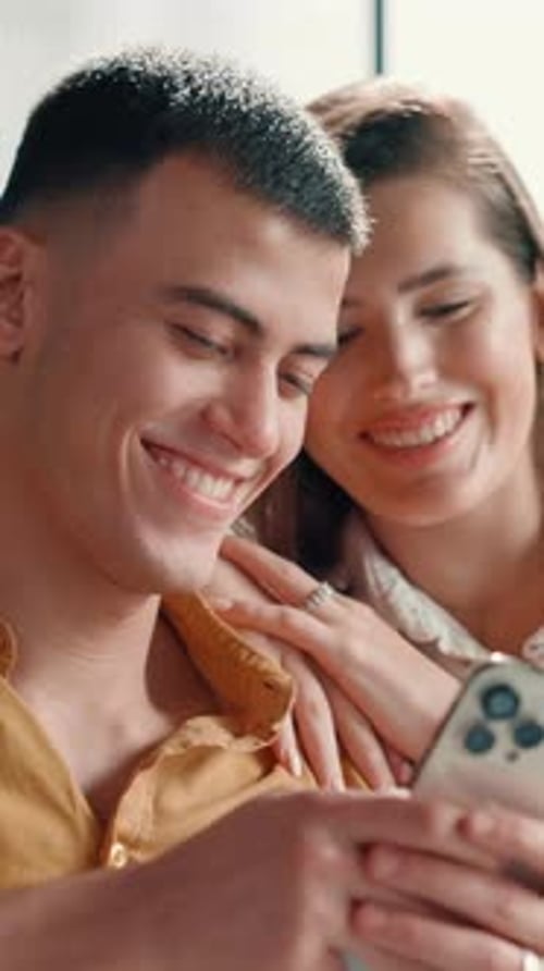 Home, couple and smile with smartphone for chat, online message and reel for laughing in lounge