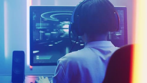 Teen playing a video game with headset at home