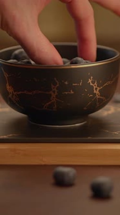 Hand Picking Fresh Blueberries from Bowl, Close-Up