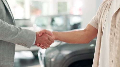 Handshake, man and car dealership with keys, salesman and customer for successful purchase