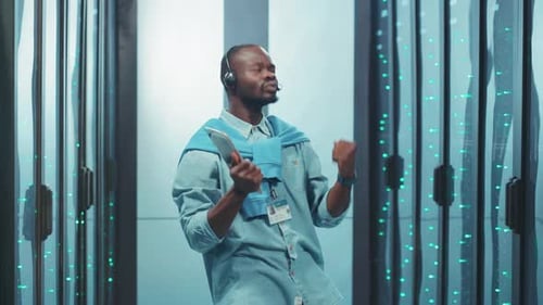 Young Adult Dancing with Tablet in Server Room