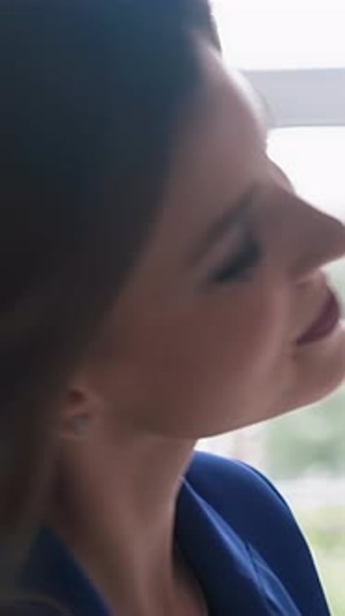 Attractive Brunette Smiling Indoors Wearing a Blazer