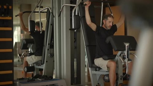 A Man Engaging in Physical Exercise at the Gym Strength Training and His Fitness Routine