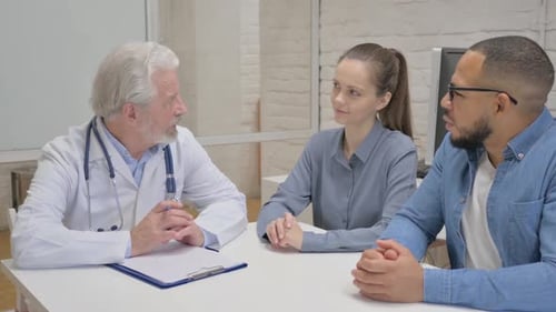 Doctor Talking to Couple in Medical Office