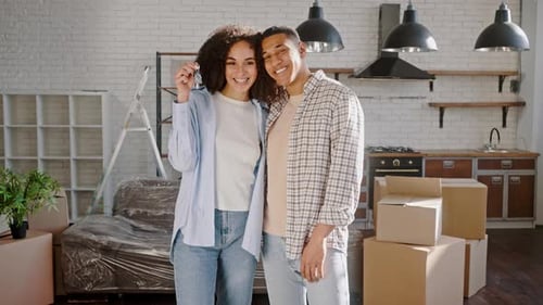 Young Multiethnic Couple Shares Positive Emotions Smiles Shows Keys of New House the are Moving