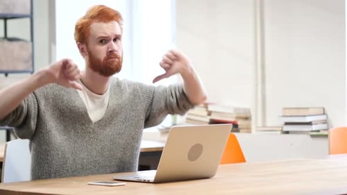 Man Gives Two Thumbs Down at Desk