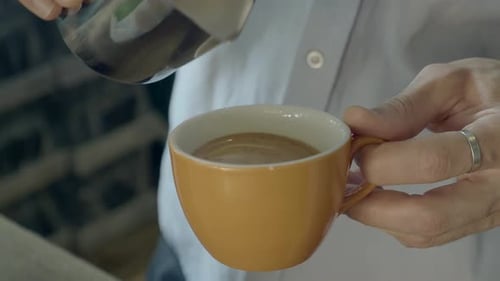 Pouring Frothed Milk Into Coffee Cup For Latte Art
