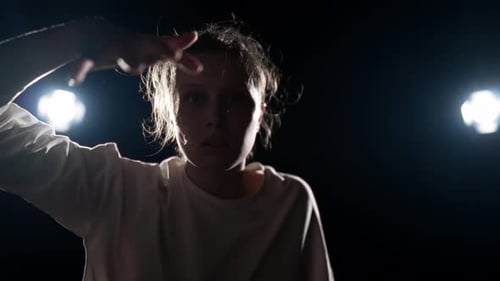 Woman Dancing Silhouetted Against Two Stage Lights