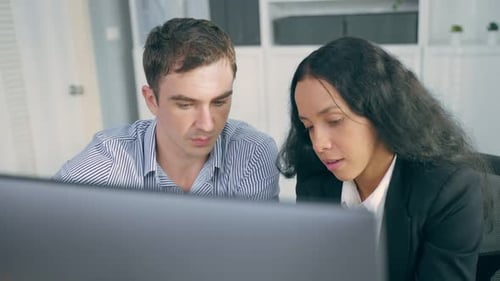 Young Latino business woman work with Caucasian man manager in office.