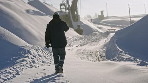 Worker Walks on Construction Site on Winter Day Stock Footage Worker at Snowcovered Quarry on Winter