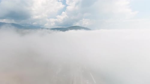 Top View of Thick Clouds with Mountain Peak on Horizon Schot Flying in Cloudy Sky with Dense Clouds