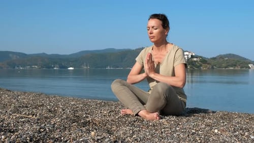 Prier pendant le yoga sur le rivage