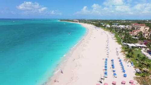 Forward aerial 4K footage showcasing the stunning coastline of Grace Bay Beach with white sand, blue