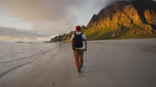 Professional Photographer Man with a Backpack Walks Along the Seashore Travel Adventure Norway