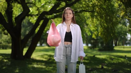 Campaña para la protección del medio ambiente Una niña hermosa muestra que debes usar bolsas de papel recicladas