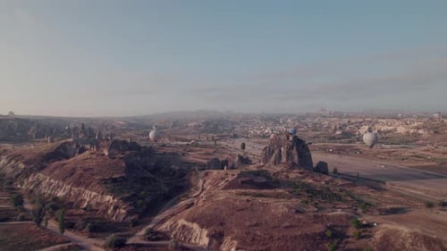 Cappadocia's rocky formations and hot air balloons at sunrise