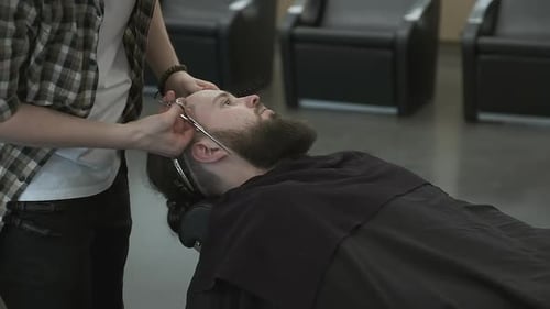 Barber Cutting Beard with Scissors in Shop